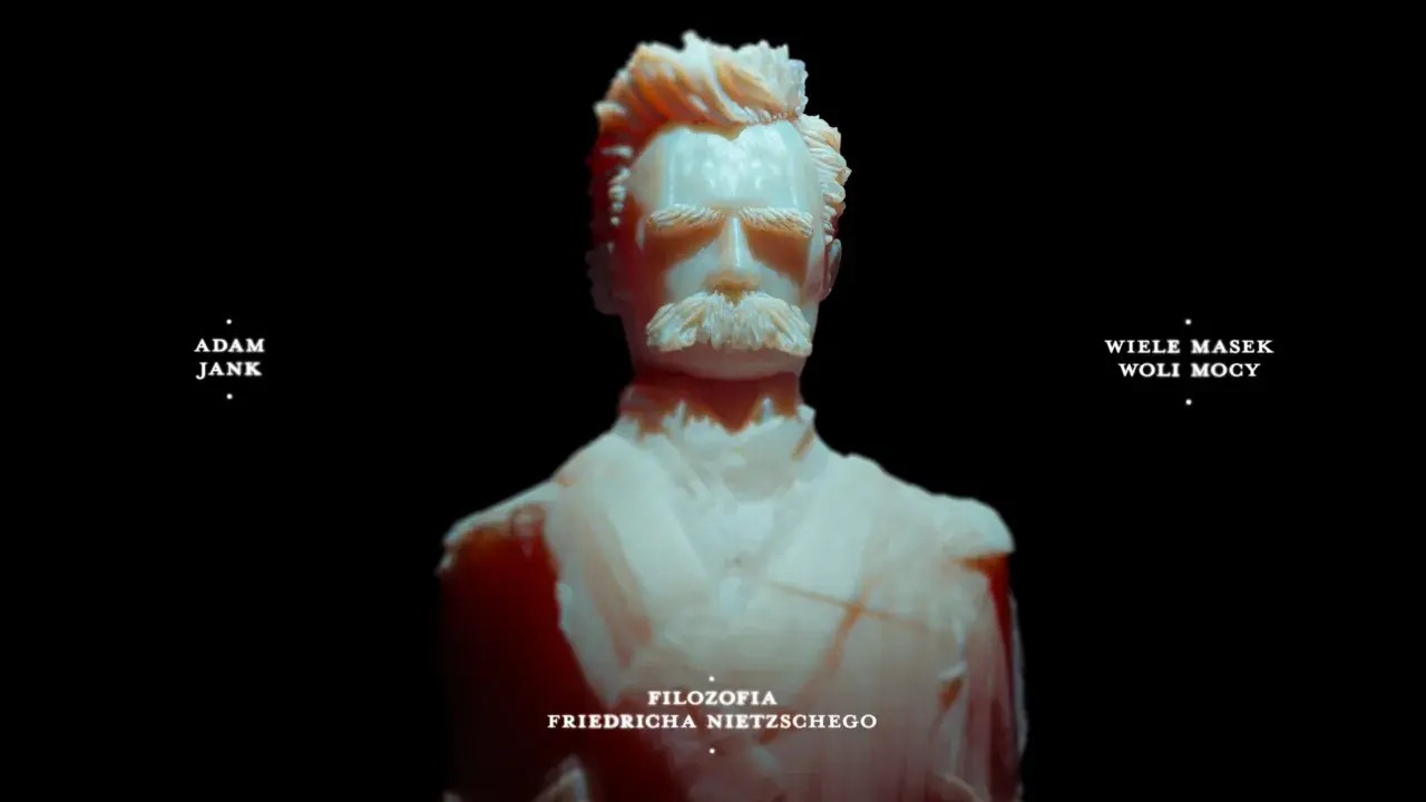Rzeźba przedstawia Friedricha Nietzschego, symbolizując jego filozofię woli mocy. Adam Jank i Wiele Masek Woli Mocy.
