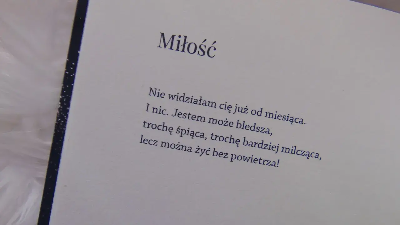 Otwarta książka z wierszem o miłości na jasnym tle.