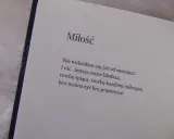 Otwarta książka z wierszem o miłości na jasnym tle.