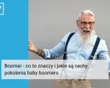 Uśmiechnięty mężczyzna z siwą brodą i tatuażami, symbol pokolenia boomers.