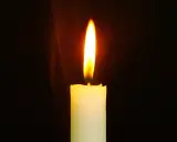 Jasny płomień świecy, niczym ulotna dusza, tańczy na tle ciemności, ogrzewając przestrzeń.
