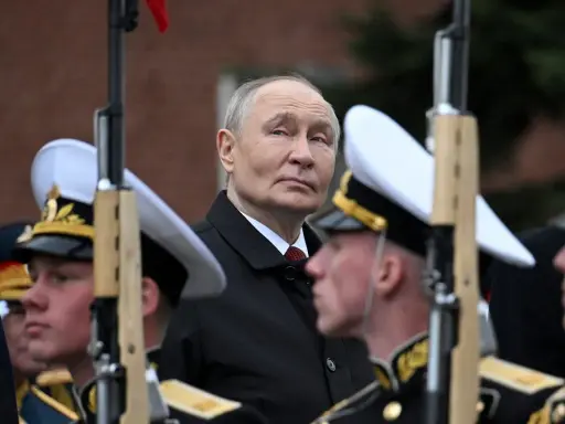 Władimir Putin w otoczeniu żołnierzy w mundurach, gdzieś w tle widać ceglany mur. To obraz, który przypomina o dawne słowo honoru.