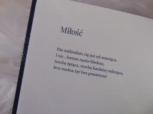 Otwarta książka z wierszem o miłości na jasnym tle.