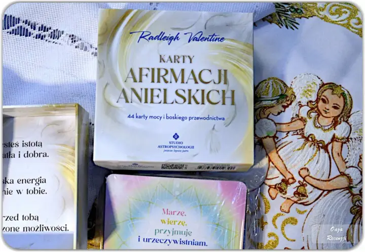 Karty afirmacji anielskich Radleigh Valentine, obok ozdobnego materiału z aniołkami, łamią konwenanse, oferując boskie przewodnictwo.