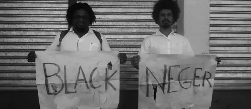 Dwóch mężczyzn trzyma transparenty z napisem "BLACK NEGER". Czy to wyraz buntu, czy prowokacja kwestionująca poprawność polityczną?